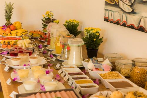 a table with a buffet of food and drinks at Pousada Ouro de Minas in Tiradentes
