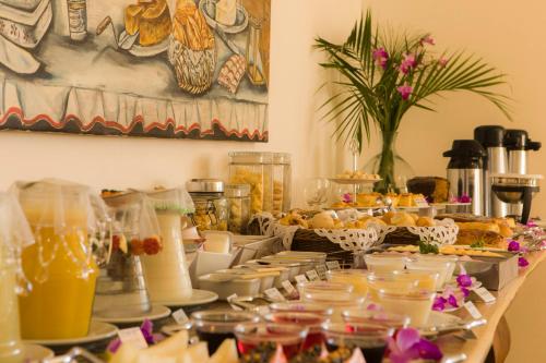a table with a buffet of food and drinks at Pousada Ouro de Minas in Tiradentes