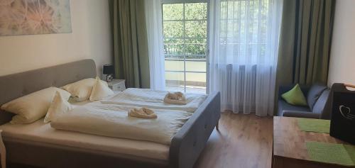 a bedroom with a bed and a large window at Appartementhaus Wimmerhof in Bad Füssing