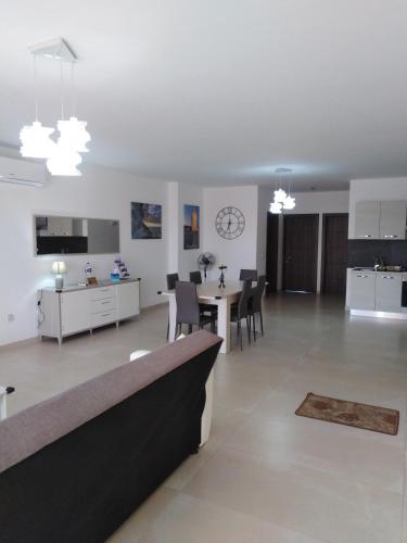 a large living room with a table and a kitchen at Paradise in Għajnsielem