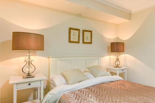 1 dormitorio con 1 cama con 2 mesas y 2 lámparas en Redhill town centre apartment by Livingo, en Redhill