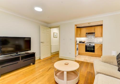 a living room with a couch and a tv and a table at Redhill town centre apartment by Livingo in Redhill