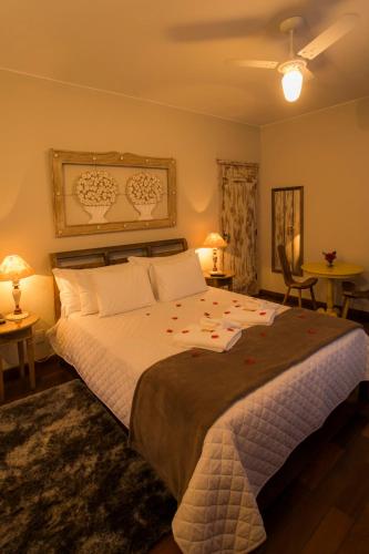a bedroom with a large bed with flowers on it at Pousada Ouro de Minas in Tiradentes