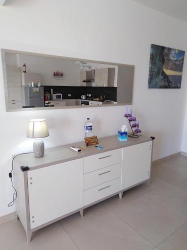 a room with a desk with a lamp on it at Paradise in Għajnsielem