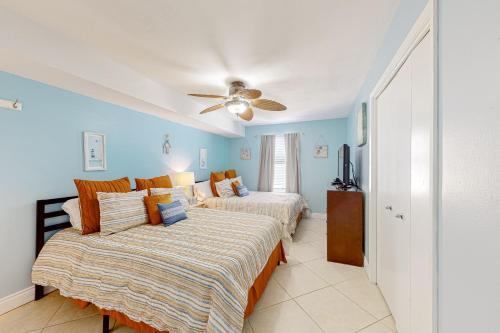 a bedroom with two beds and a ceiling fan at Phoenix Vacation Rentals in Orange Beach