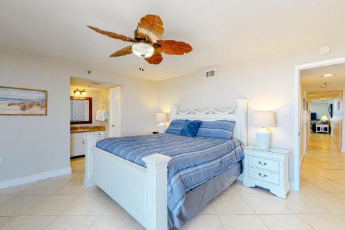 a bedroom with a white bed and a ceiling fan at Phoenix Vacation Rentals in Orange Beach