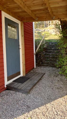 a front door of a red house with stairs at Vandrarhemmet Tallbacka/Ängelsberg Hostel in Ängelsberg