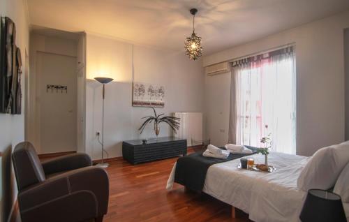 1 dormitorio con 1 cama, 1 silla y 1 ventana en Akrata's Elegant Luxury Suite en Akrata