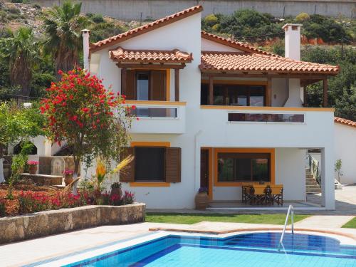 a house with a swimming pool in front of it at Villa Lemonia in Malia