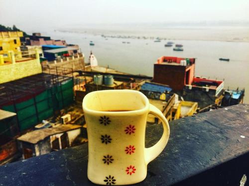 une tasse de café assise au-dessus d'une table dans l'établissement Yogg Hostel, à Varanasi