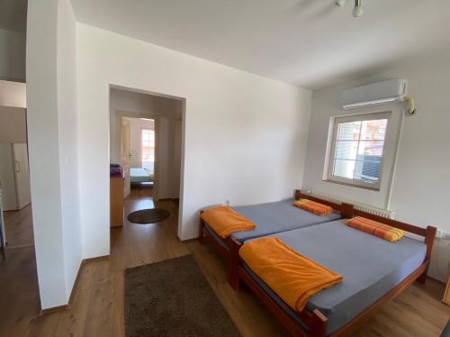 a bedroom with a bed with an orange blanket at Apartmani Jovana in Jagodina