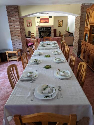 a dining room with a long table with plates and silverware at EL PINAR DE BARDENA in Carcastillo