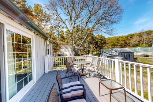 a porch with chairs and a table on it at Whitman Surf Cottage & Great Hollow Retreat in Truro