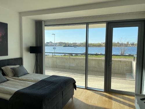 a bedroom with a bed and a view of the water at Rannakivi Riverside apartments in Pärnu