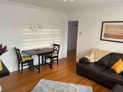One bed cozy flat في دارتفورد: غرفة معيشة مع طاولة وأريكة