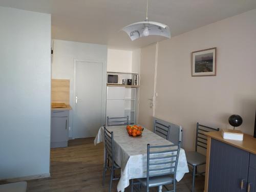 une cuisine et une salle à manger avec une table et des chaises dans l'établissement Appartement restauré à 50 m de la plage, à Saint-Hilaire-de-Riez