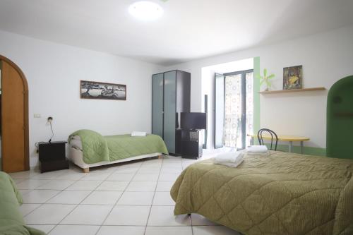 a bedroom with two beds and a television in it at PALAZZO PELLEGRINO vietri in Vietri sul Mare