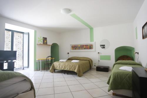 a bedroom with two beds with green and white at PALAZZO PELLEGRINO vietri in Vietri sul Mare