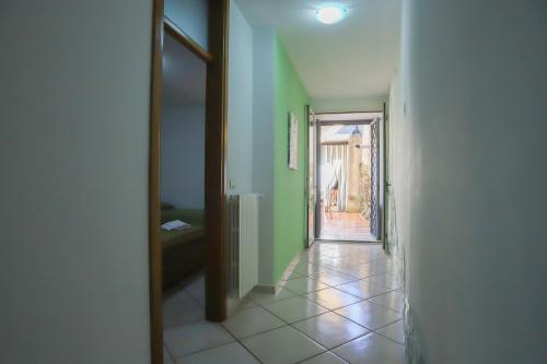 a hallway with green walls and a door to a room at PALAZZO PELLEGRINO vietri in Vietri sul Mare