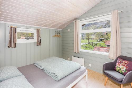 una camera da letto con un letto, una sedia e una finestra di Flåm Hostel a Flåm
