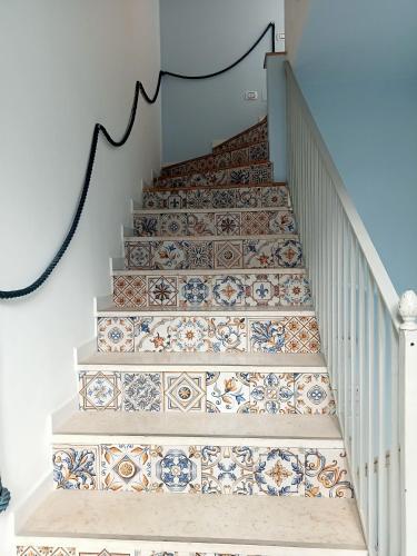 a staircase with ceramic tiles on the stairs at Borgo 800 in San Nicola Arcella