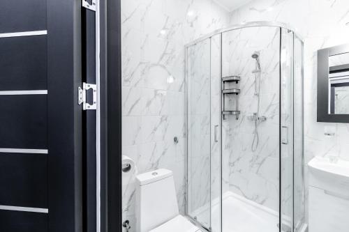 a bathroom with a shower and a toilet and a sink at Opera Passage Hotel & Apartments in Lviv