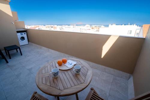 a table with two oranges on top of a balcony at Precioso ático con vistas al mar Parking gratuito in Corralejo