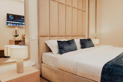 a bedroom with a large white bed with blue pillows at Cesare ai Cavalieri Suites in Rome