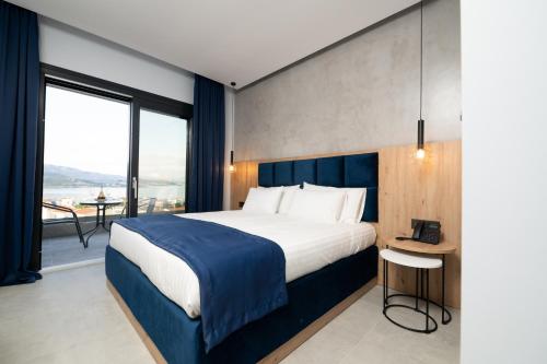 a bedroom with a large bed and a large window at Panorama Hill Hotel in Iraklitsa