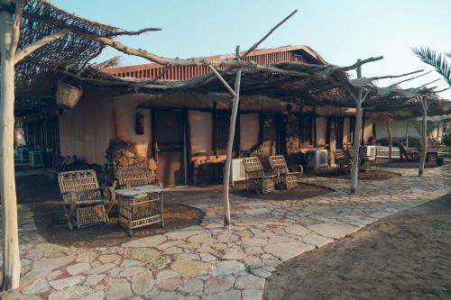 a house with chairs and a building with a roof at Sayadeen Village - Red Sea Riviera in Nuweiba