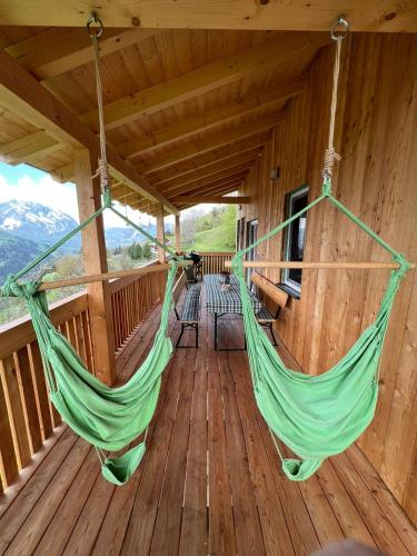 a porch with two hammocks on a wooden deck at Gemütliches Häuschen "Bergblick Hollnhof" lädt zum verweilen ein in Donnersbach