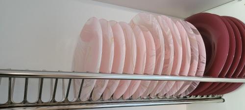 a stack of pink plates on a shelf in a refrigerator at A ESTRENAR PRECIOSOS APARTAMENTOS APARTHOTEL INTER2, NEW APARTMENTS lN APARTHOTEL 12 months open! self check in! RESERVA Garaje! in Salou