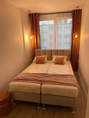 a bed in a room with a large window at Apartament 80’s in Kołobrzeg