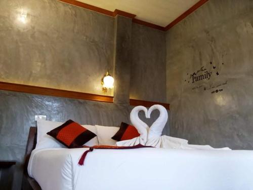 a bedroom with a bed with two swans forming a heart at Safina Pool Villa Koh Lanta in Ko Lanta