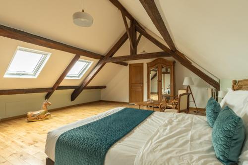 a bedroom with a large bed in the attic at L'Ecurie Gourmande in Thaon