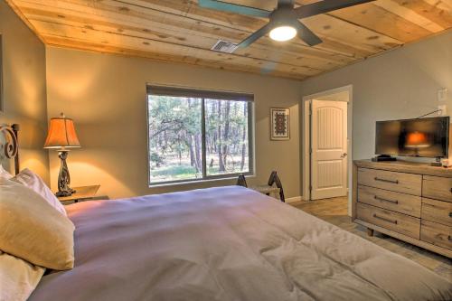 a bedroom with a bed and a flat screen tv at 1 Mi to Rainbow Lake Newly Built and Woodsy Retreat in Lake of the Woods