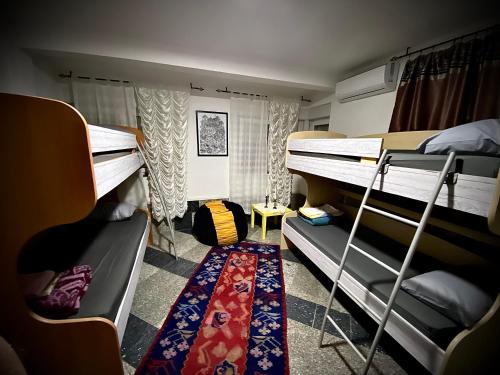 Habitación compartida con 2 literas y alfombra. en Hostel Backpackers, en Mostar