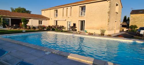 une grande piscine devant une maison dans l'établissement Gîte et mobile home La Gloriette proche Futuroscope, à Neuville-du-Poitou