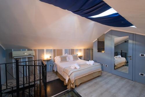 a bedroom with a large bed with white sheets at Hotel Borgo Vistalago in Trevignano Romano