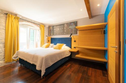 a bedroom with a bed with yellow curtains and a window at Domus Maritima in Trogir