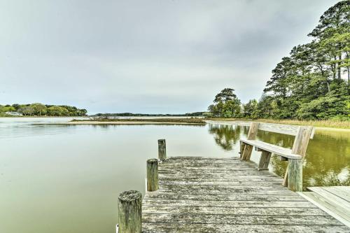 a wooden dock on a lake with a bench at Bayfront Retreat with Game Room and Outdoor Pool! in Exmore