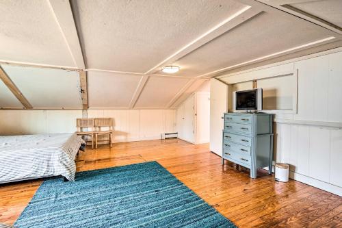 a bedroom with a bed and a dresser and a television at Cozy Castleton Cabin with Fire Pit and Water Access! in Castleton