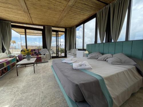 a bedroom with a large bed in a room with windows at Il Dammuso di Noto - Villa con Piscina privata in Avola