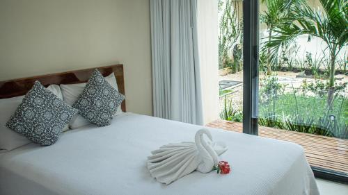 a bedroom with a bed with a swan decoration on it at Moonshine Tulum Hotel & Hostel in Tulum