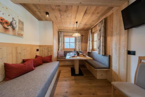 Habitación con paredes de madera, sofá y mesa. en Agriturismo Lüch de Vanc, en San Martino in Badia