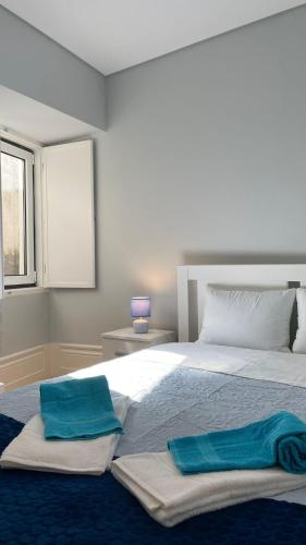 a bedroom with a large bed with two towels on it at São Bartolomeu Apartment 3 in Coimbra