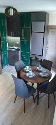a kitchen with a wooden table with chairs and a tableasteryasteryasteryasteryastery at Tajna037 in Kruševac