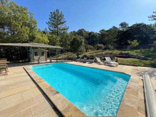 - une piscine dans une cour avec des chaises et des arbres dans l'établissement Gîte 