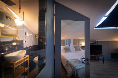 a bedroom with a bed and a bathroom with a mirror at Hotel Borgo Vistalago in Trevignano Romano