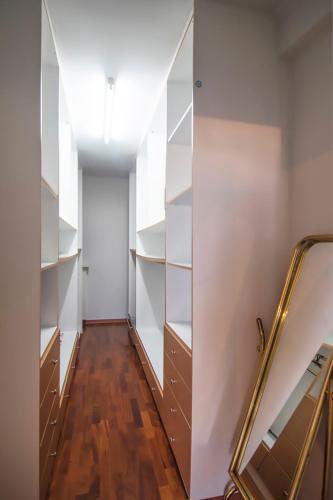a walk in closet with white shelves and a mirror at Akrata's Elegant Luxury Suite in Akrata
